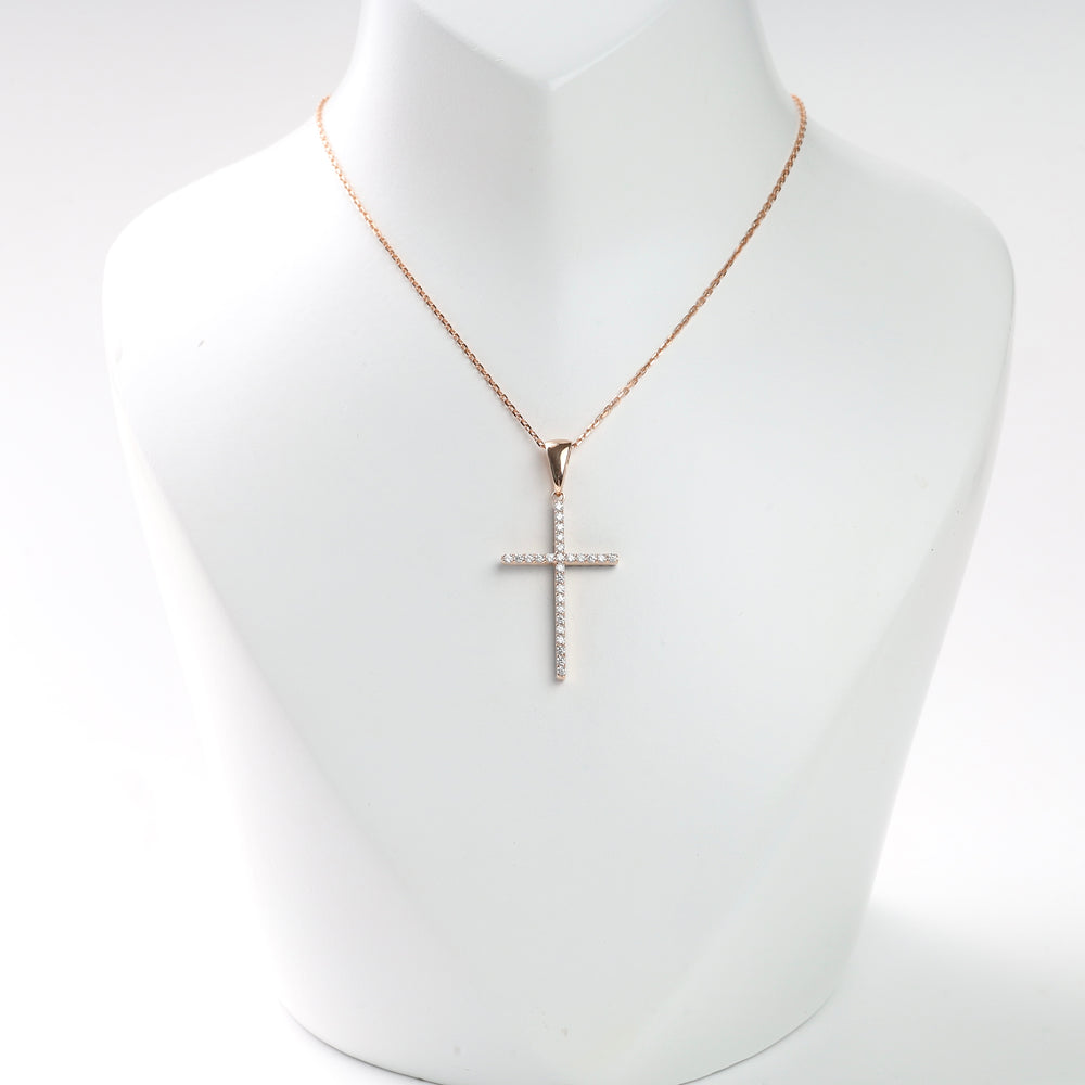 Gold chain necklace with a cubic zirconia cross pendant on a display bust.
