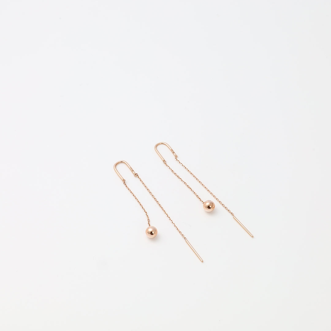 Pair of 14k gold threader drop earrings with ball charms on a white background, minimalist Ukrainian Jewelry for women.