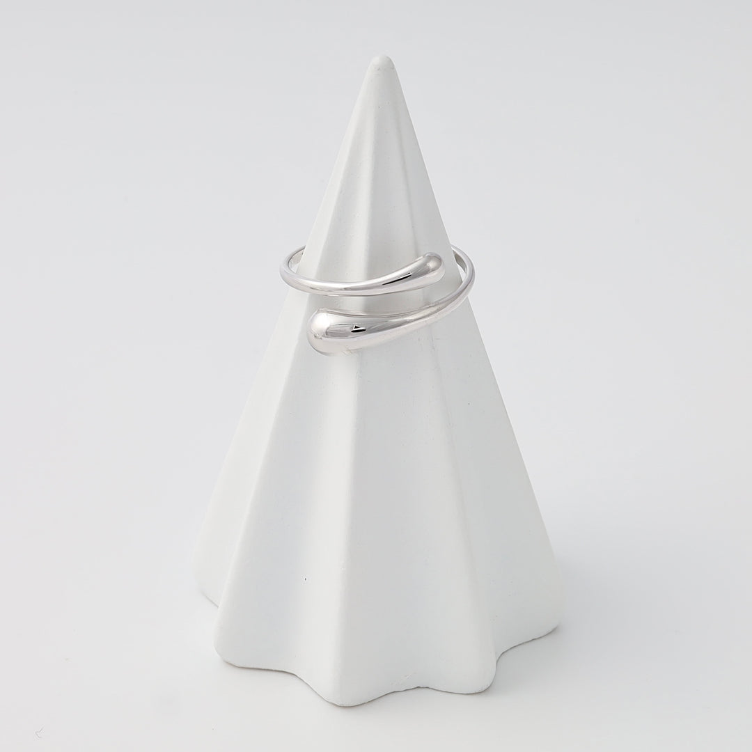 Sterling silver open wrap ring with smooth teardrop ends on a white cone display, minimalist Ukrainian Jewelry gift ring.