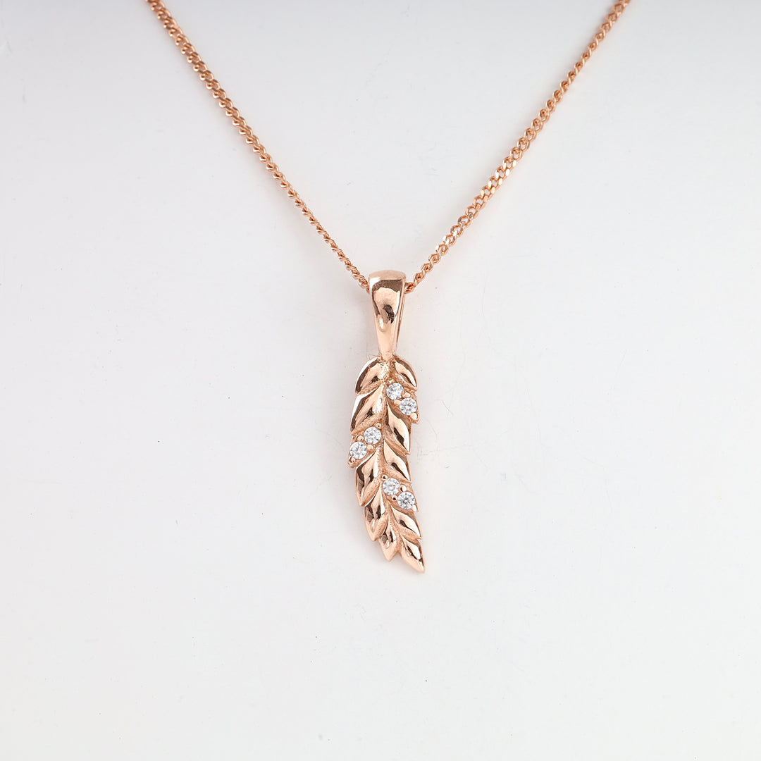 Rose gold necklace with a leaf-shaped pendant accented by small clear stones, shown against a white background.