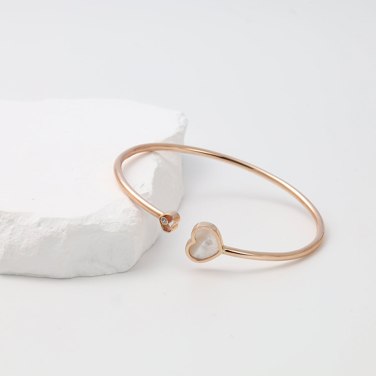 Rose gold bracelet with open heart and small crystal accent on white stone display, Ukrainian Jewelry, delicate gold bangle gift.