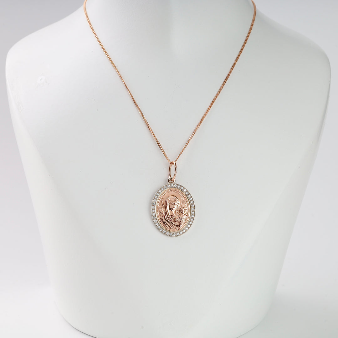 Rose gold necklace with round Virgin Mary medallion charm and clear crystal border on display bust. Religious pendant jewelry.