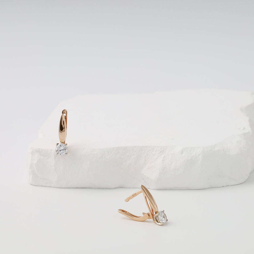 14k gold hoop earrings with single round cubic zirconia stones on white display, Ukrainian Jewelry, minimalist gold earrings.