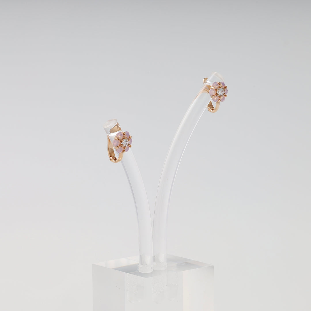 14k gold floral gemstone stud earrings displayed on clear stand, Ukrainian Jewelry for pink stone earrings and gold flower earrings shoppers.