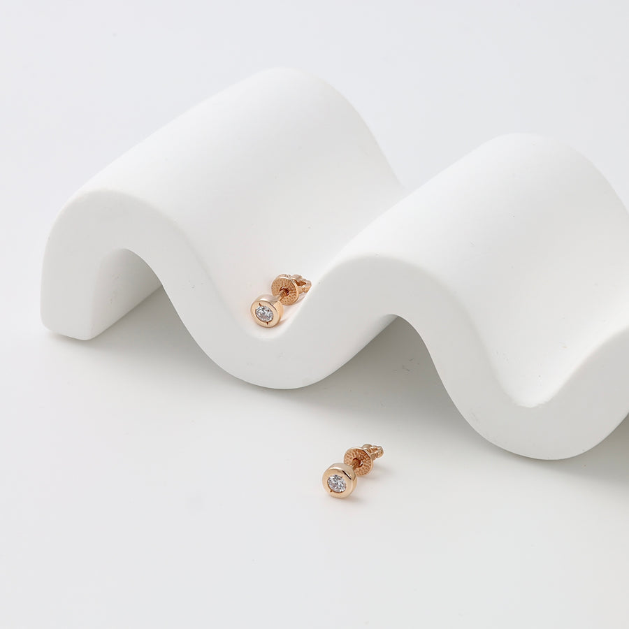 Pair of gold stud earrings with round clear stones on white display, minimalist Ukrainian Jewelry perfect as everyday gold earrings.