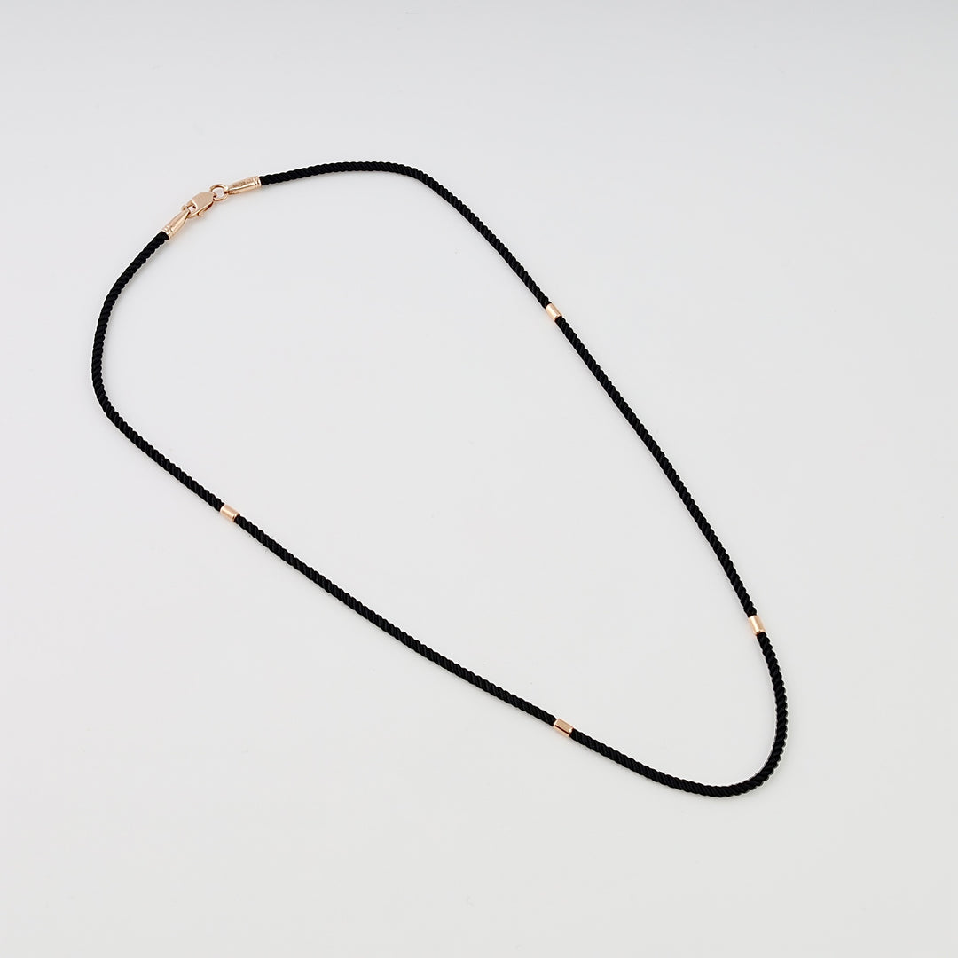 Black cord necklace with small 14k gold tube accents and clasp, minimalist chain style Ukrainian Jewelry for everyday wear.