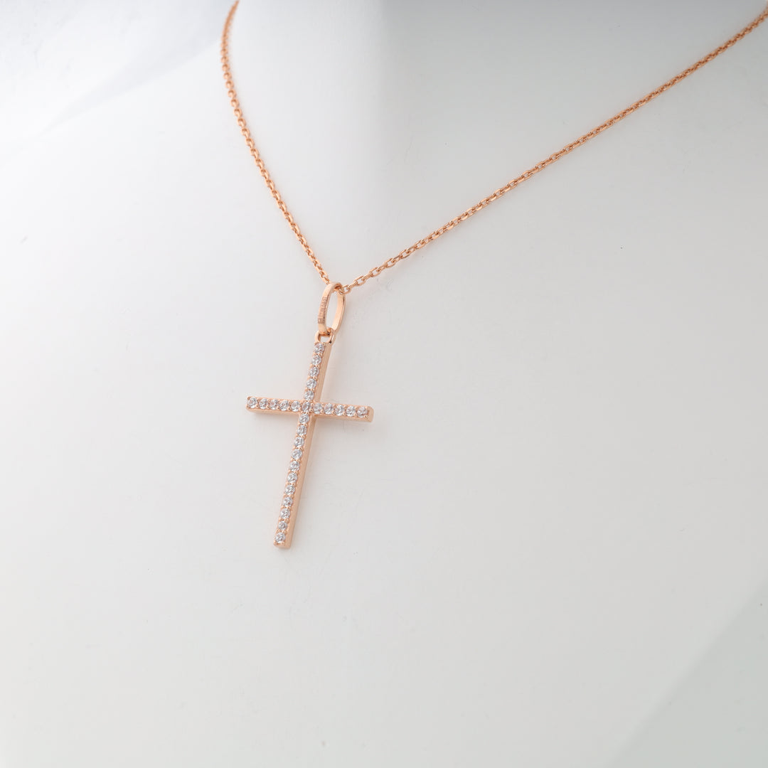 Rose gold cross pendant necklace with clear cubic zirconia stones displayed on a white mannequin bust.