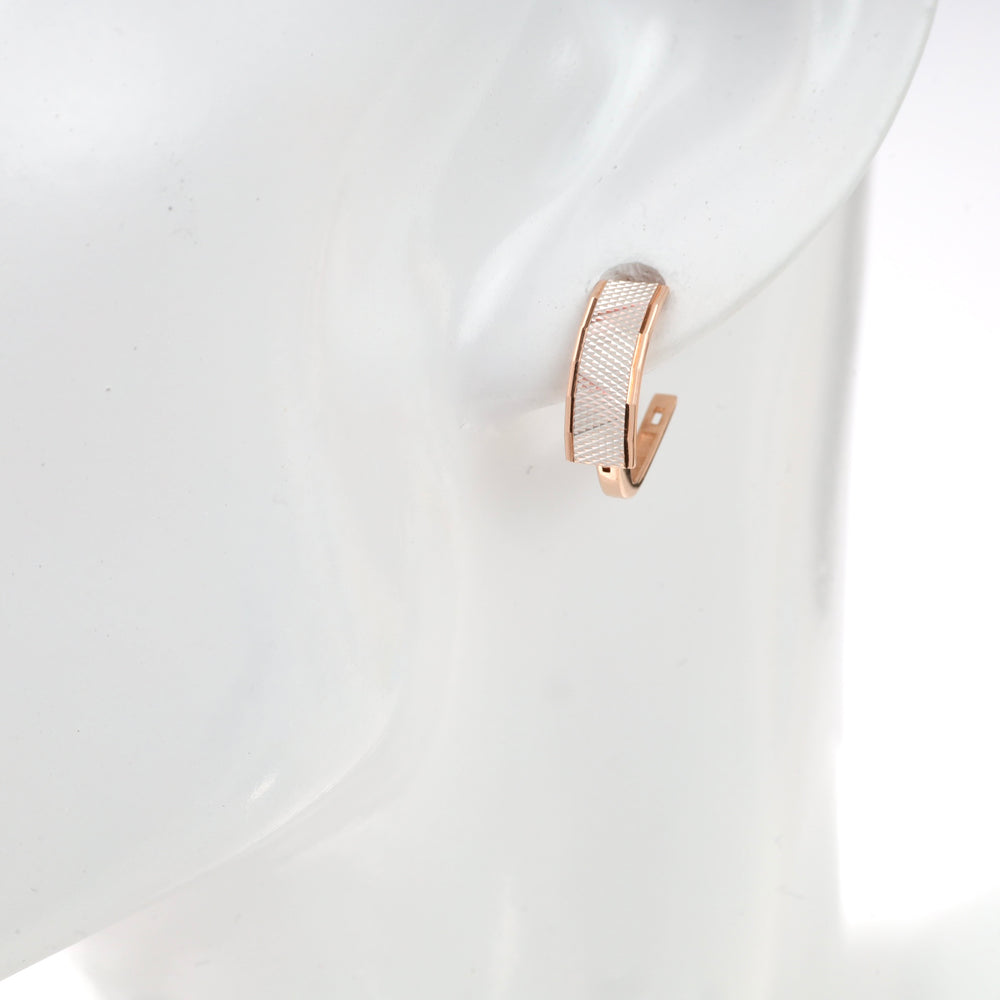 Rose gold textured hoop earring on mannequin display.