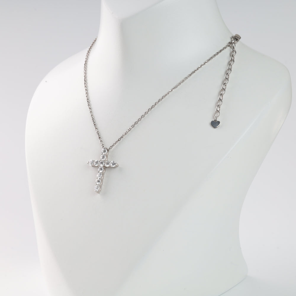 Silver chain necklace with a rhinestone cross pendant on a display stand.