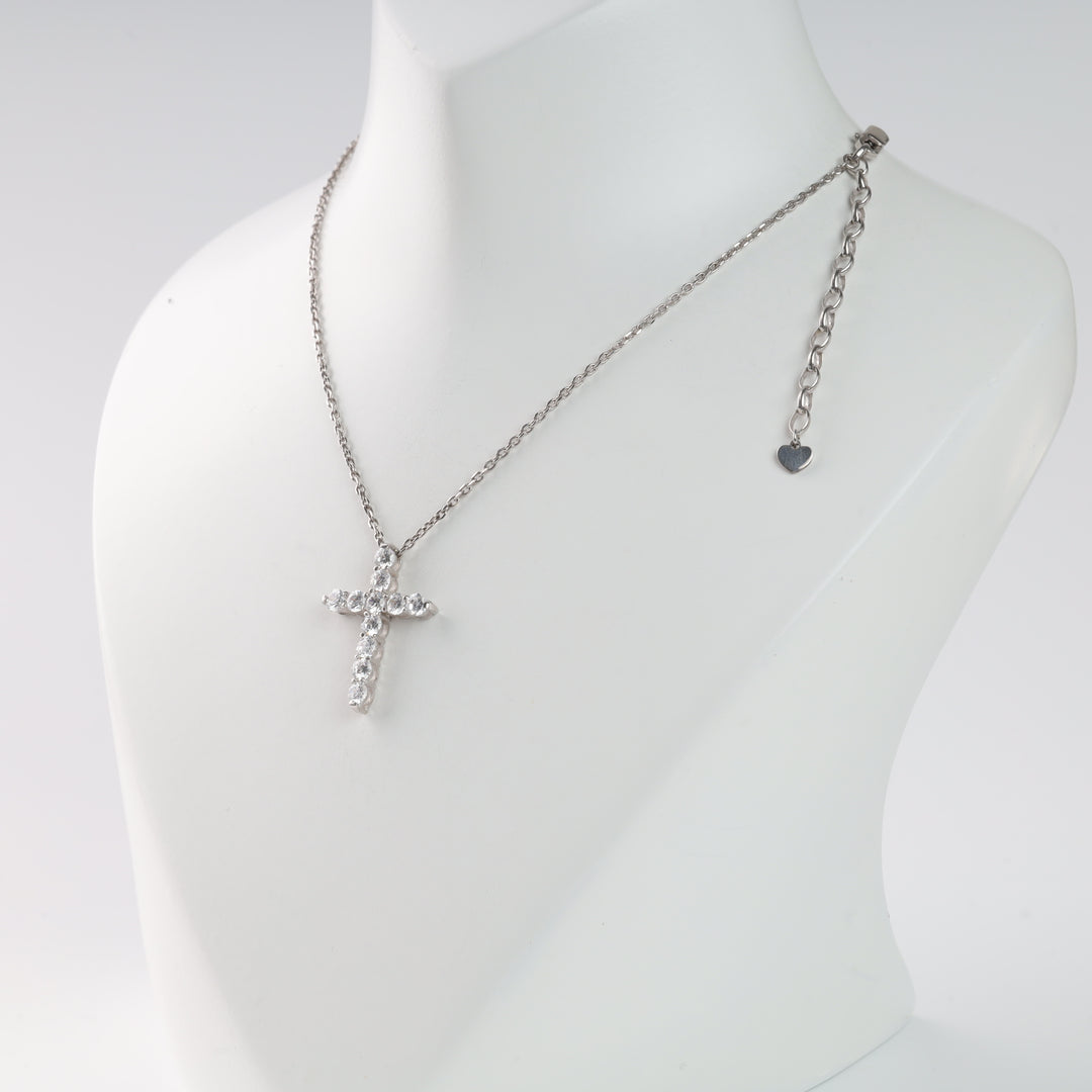 Silver chain necklace with a rhinestone cross pendant on a display stand.