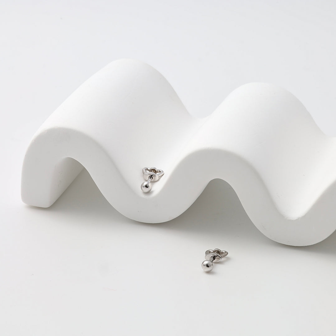 Pair of sterling silver heart stud earrings with drop ball detail on white display, minimalist Ukrainian Jewelry for everyday studs.