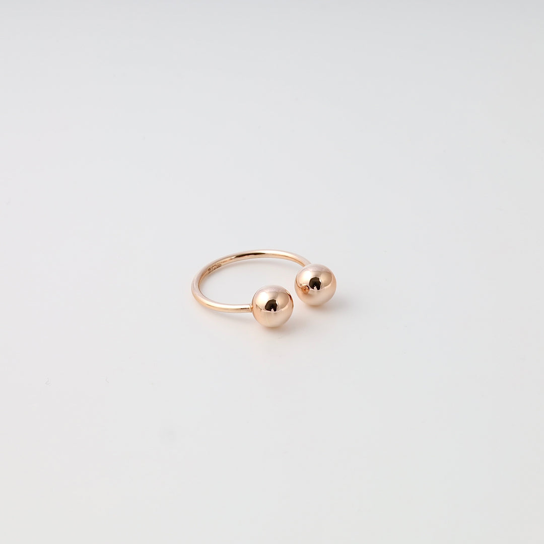 Minimalist 14k gold open ring with two polished ball ends on white background, modern Ukrainian Jewelry, gold statement ring.