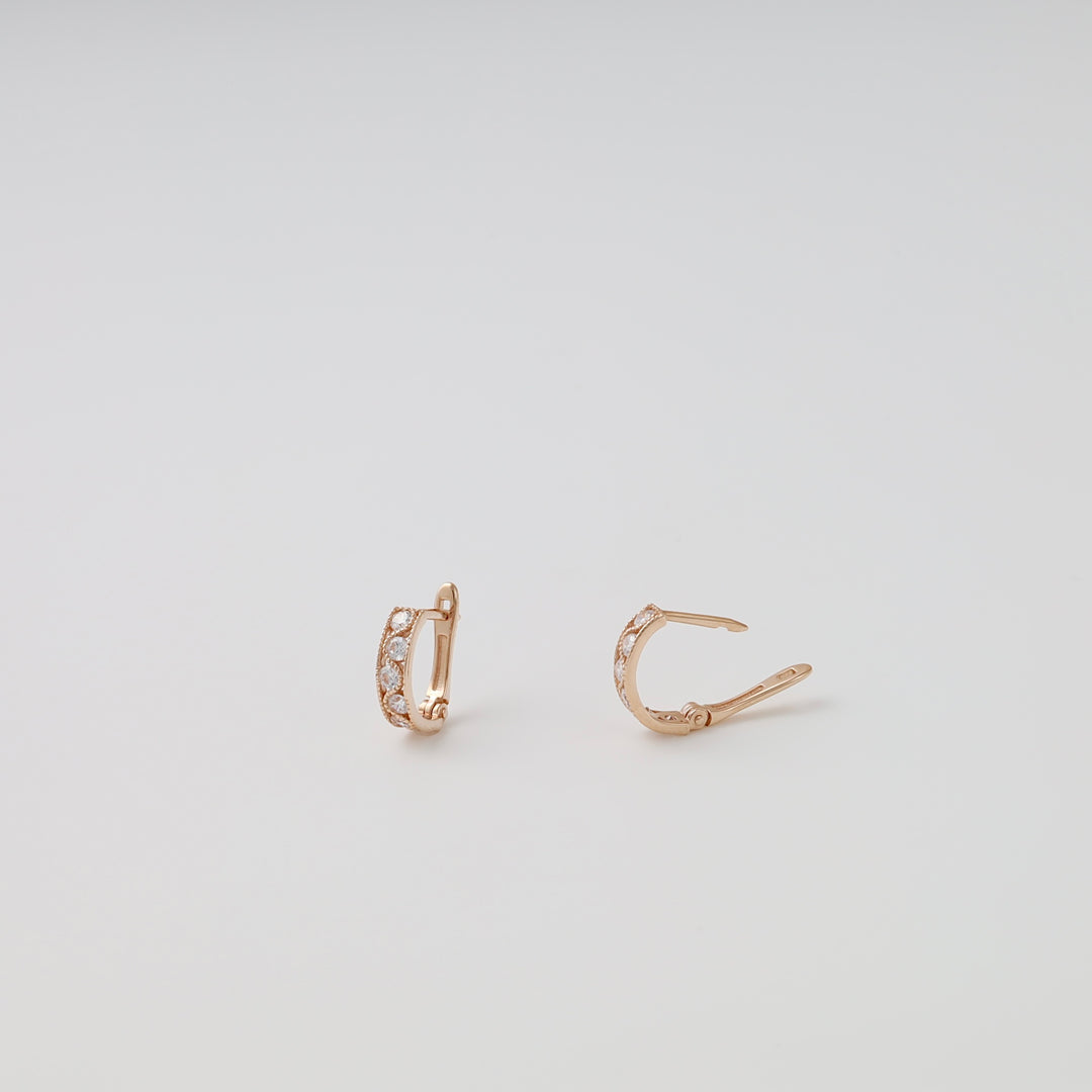 Pair of 14k gold huggie hoop earrings with clear stones on white background, Ukrainian Jewelry, dainty gold hoop earrings.