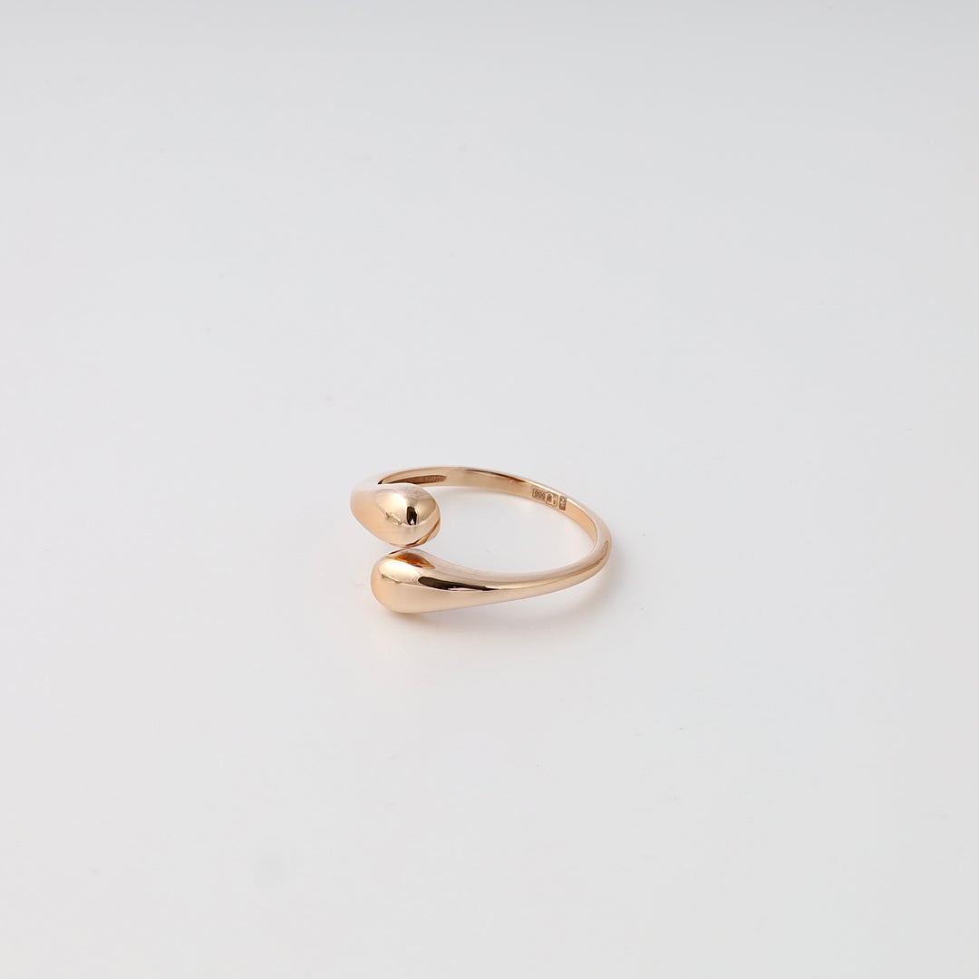 Minimalist 14k gold open ring with two teardrop ends on white background, modern stackable band Ukrainian Jewelry.