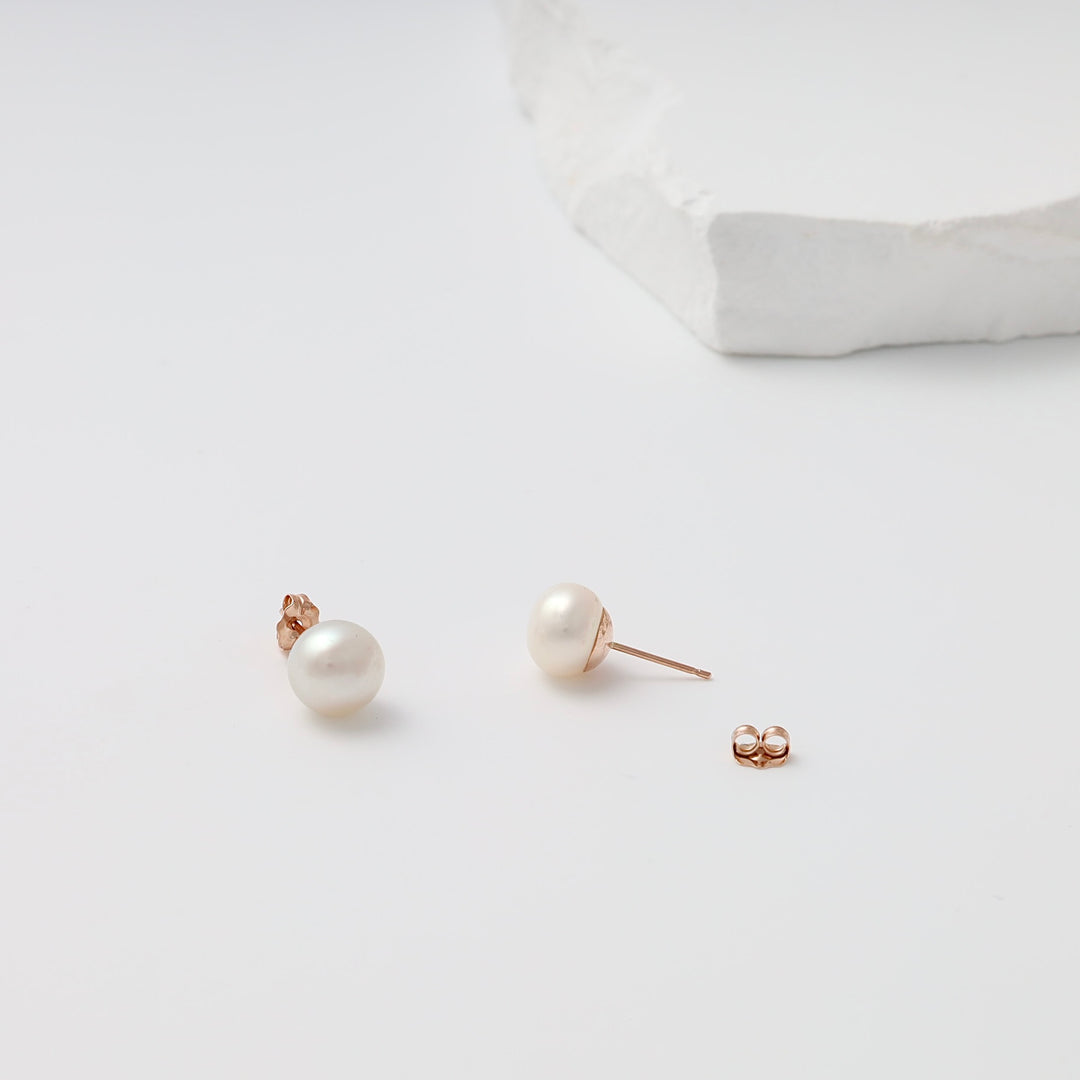 Pair of 14k gold pearl stud earrings with push backs on white background, Ukrainian Jewelry, classic pearl earrings gift.