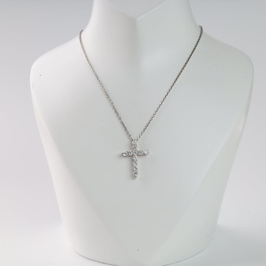 Silver chain necklace with a crystal cross pendant on a display stand.