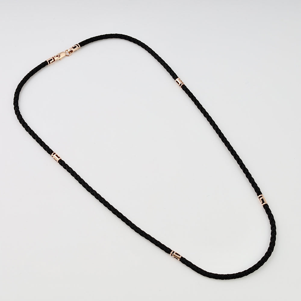 Black braided cord necklace with 14k gold accents and clasp, displayed on white background, minimalist Ukrainian Jewelry chain necklace.