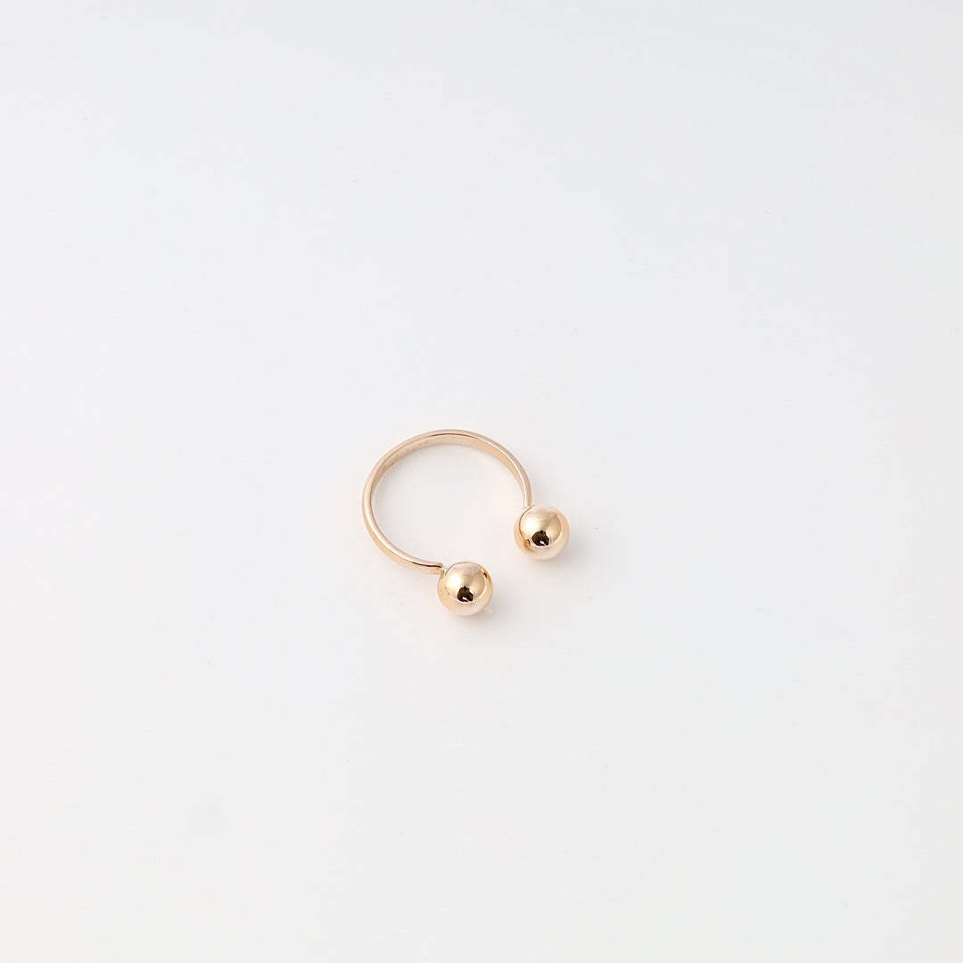 Minimalist 14k gold open ring with two ball ends on white background, Ukrainian Jewelry, modern gold ring gift.