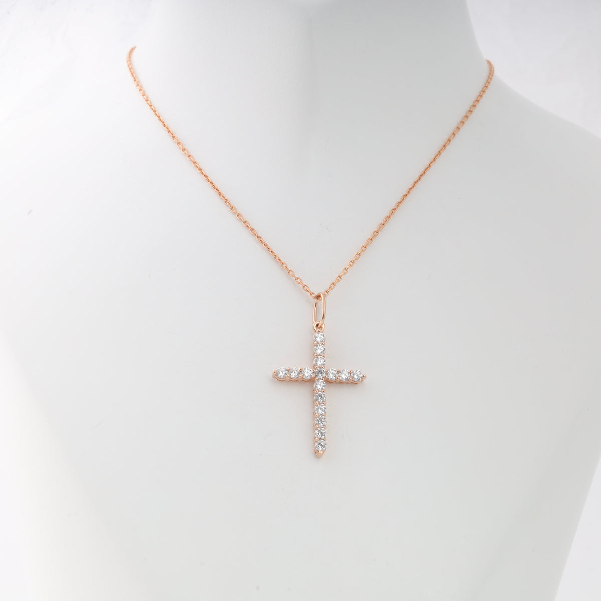 Rose gold chain necklace with a crystal cross pendant displayed on a white mannequin, Christian jewelry, gift necklace.