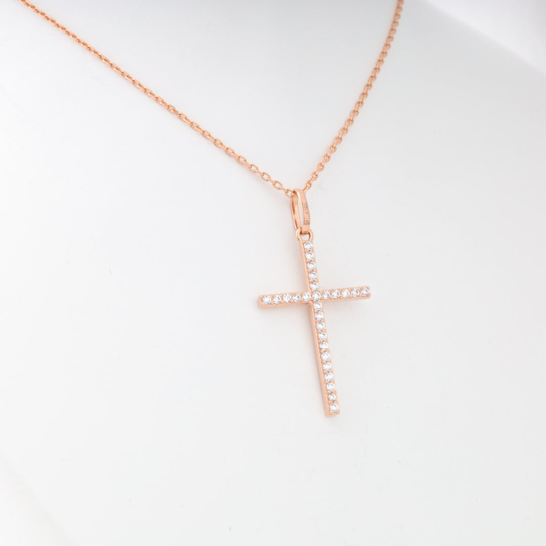 Rose gold chain necklace with a crystal-studded cross pendant displayed on a white mannequin bust.