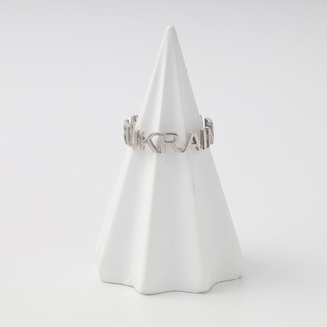 Sterling silver ring spelling “UKRAINE” displayed on a white cone, Ukrainian Jewelry ideal as a silver word ring gift.
