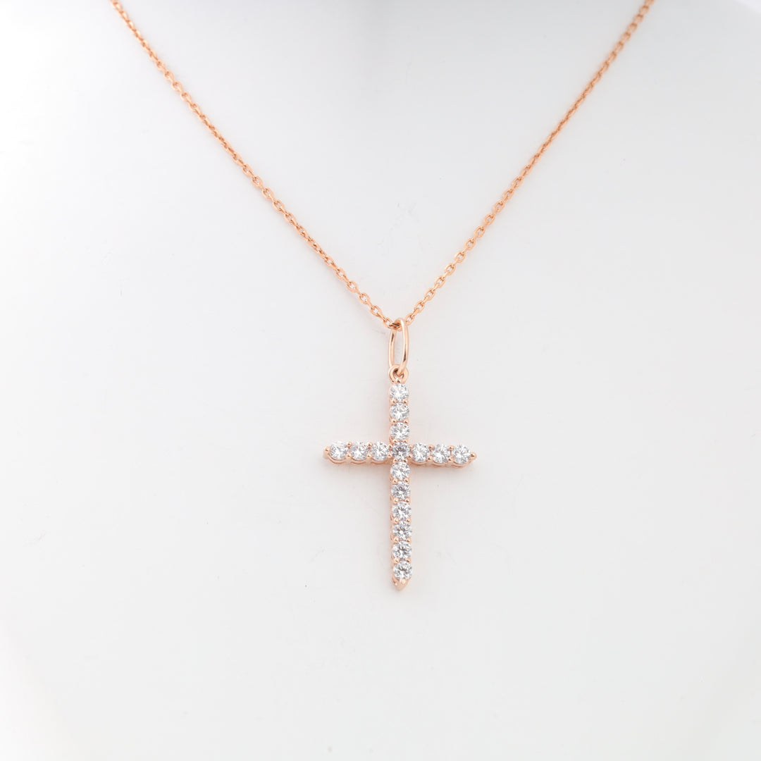 Rose gold chain necklace with a cross pendant set with clear cubic zirconia stones, shown on a display bust.