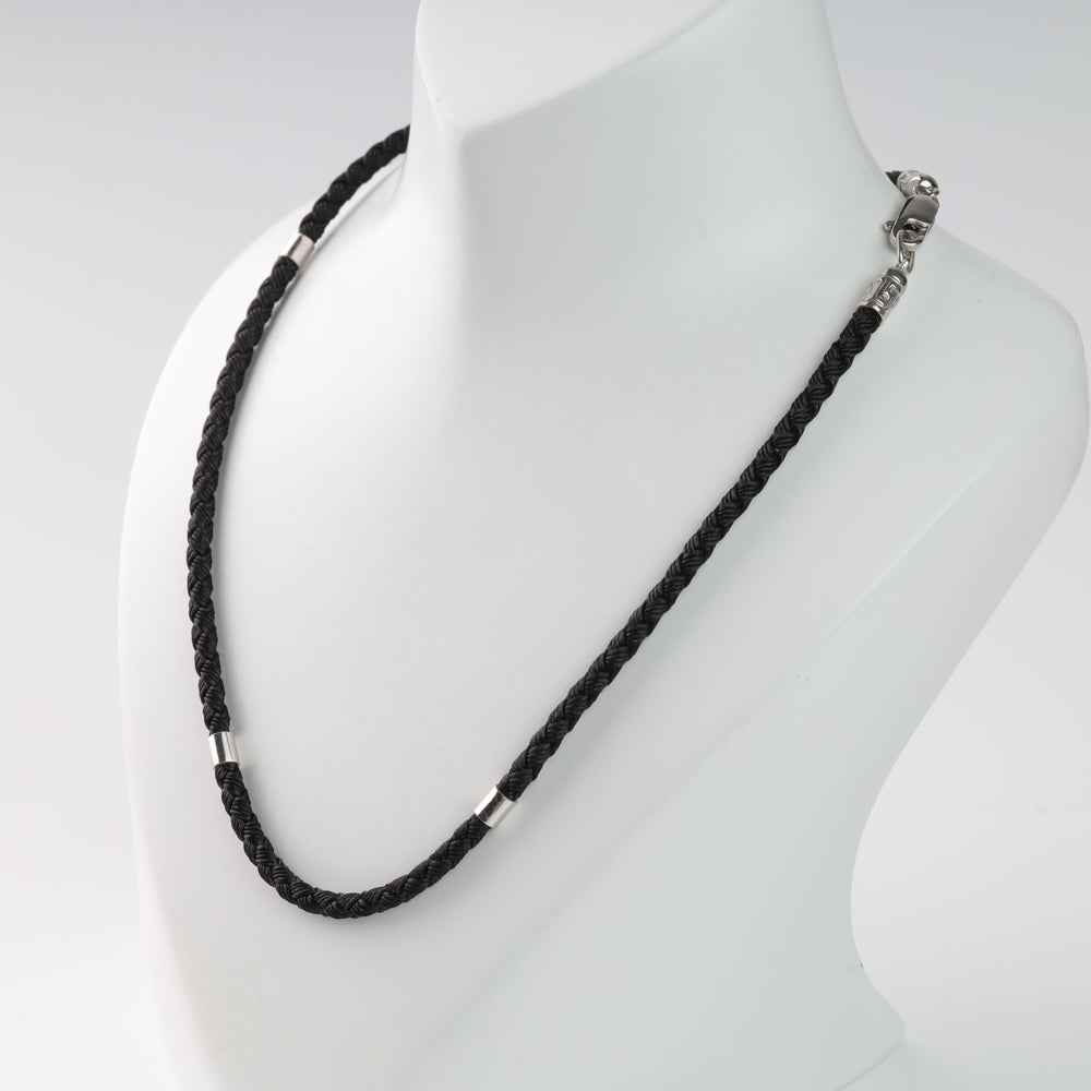Black braided leather necklace with silver accents on a white display bust.