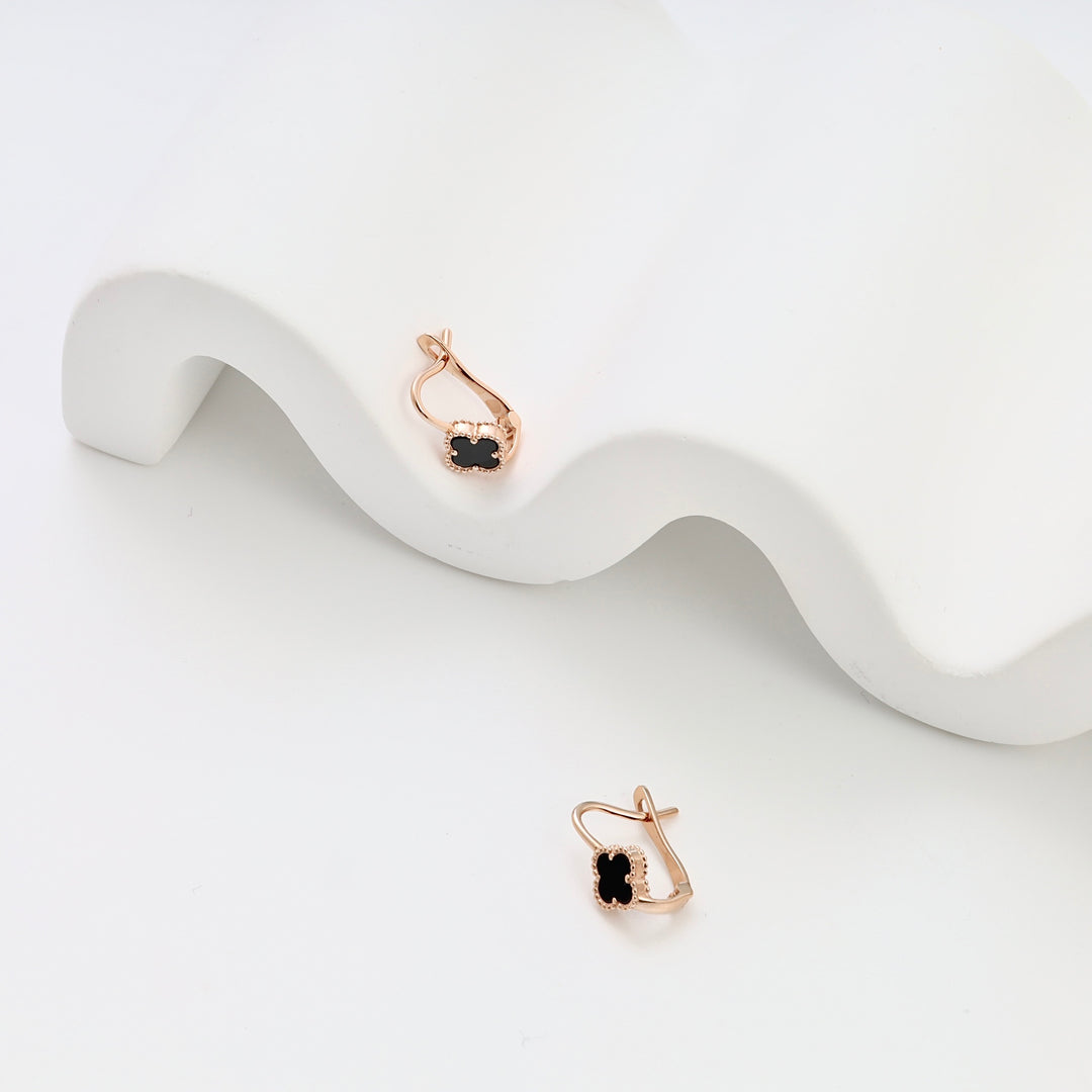 14k gold earrings with small black stone drops on a white display, Ukrainian Jewelry, delicate gold drop earrings for women.