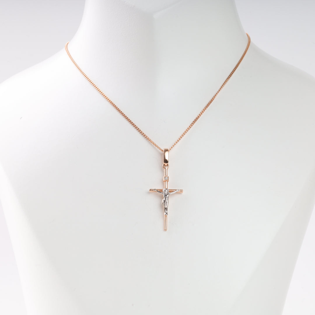 Gold chain necklace with a two-tone crucifix pendant displayed on a white bust, Christian cross jewelry.