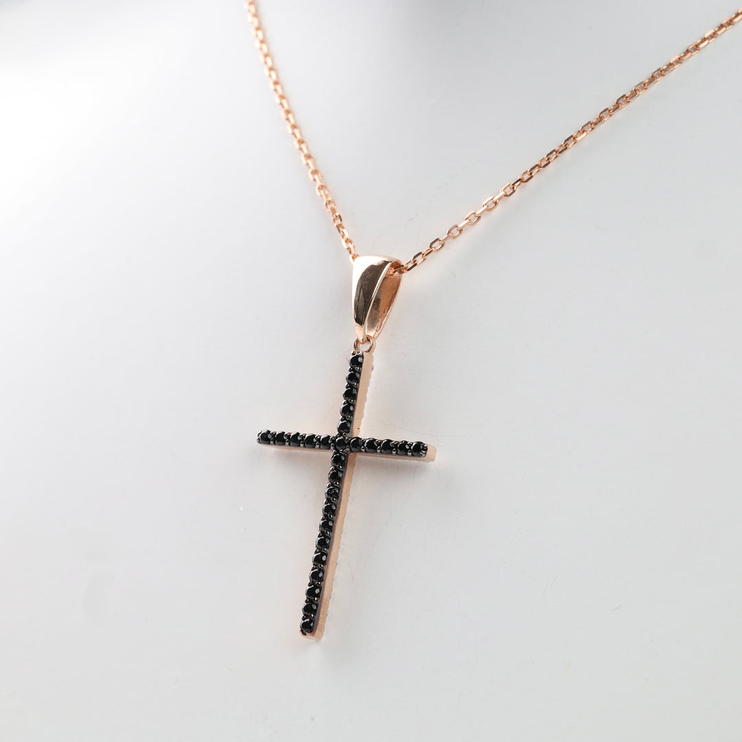 Rose gold chain with black crystal cross pendant.