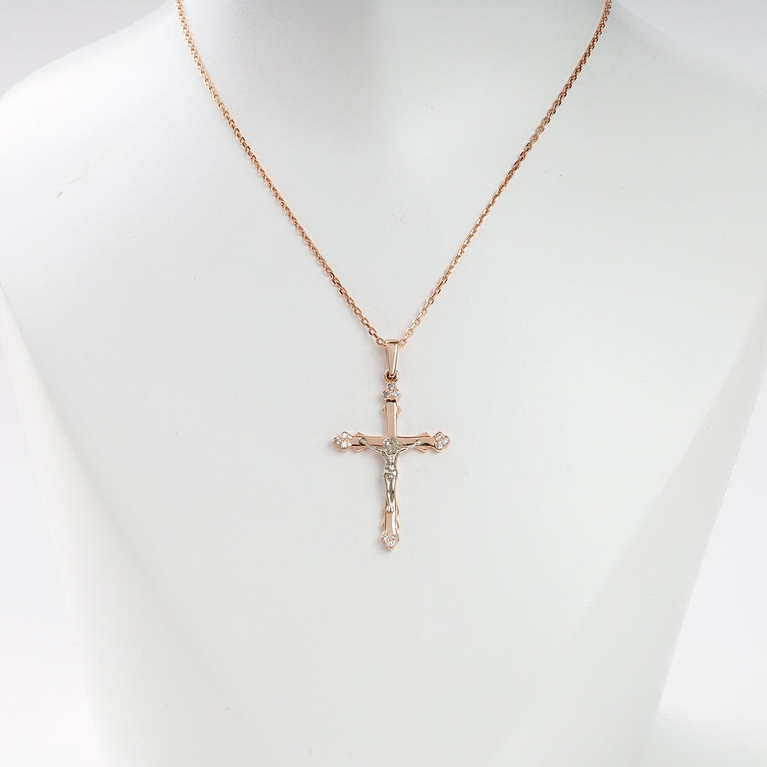 Rose gold crucifix necklace with silver Jesus figure and diamond accents displayed on a white mannequin bust.