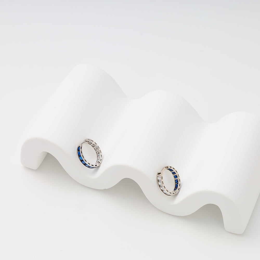 Sterling silver hoop earrings with blue stones on white display, Ukrainian Jewelry, silver huggie hoops, gemstone earrings.