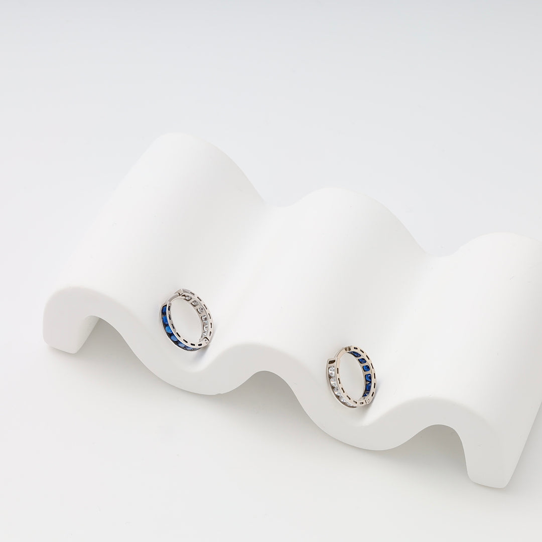 Sterling silver hoop earrings with blue stones on white display, Ukrainian Jewelry, silver huggie hoops, gemstone earrings.