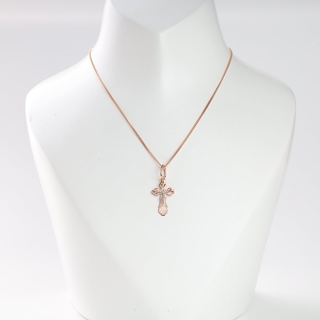 Rose gold cross pendant necklace with engraved details shown on a white display bust.