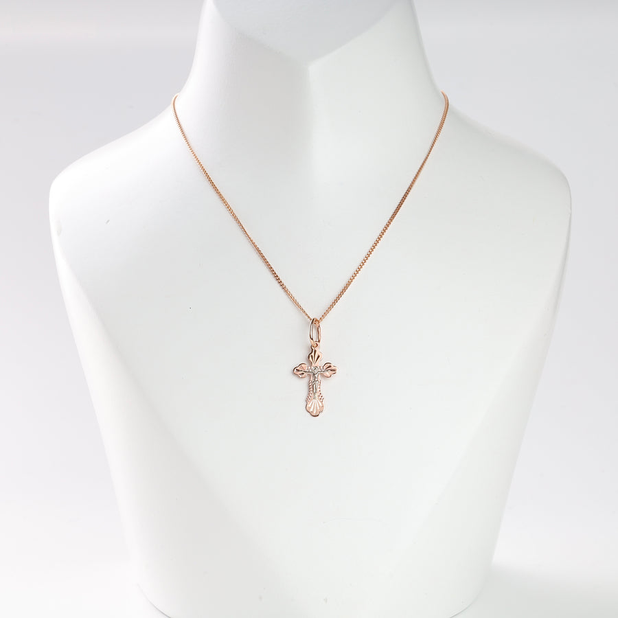 Rose gold cross pendant necklace with engraved details shown on a white display bust.