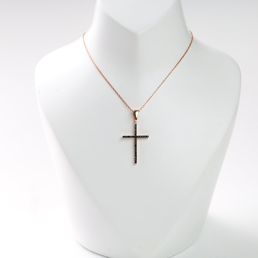 Rose gold necklace with a black crystal cross pendant on a display bust.