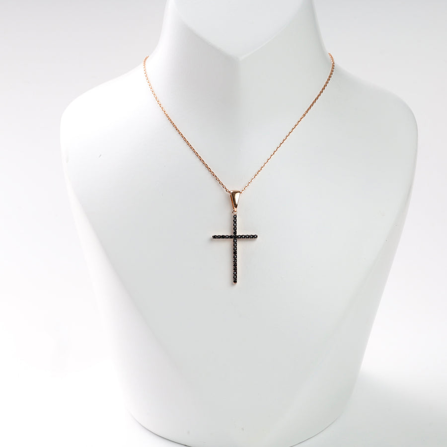 Rose gold necklace with a black crystal cross pendant on a display bust.