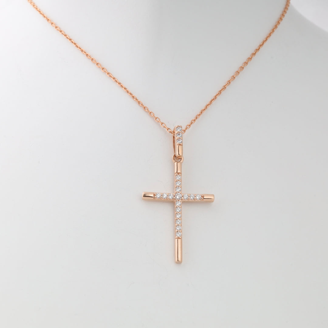 Rose gold cross pendant necklace with clear crystals on a display bust, fine chain, religious jewelry.