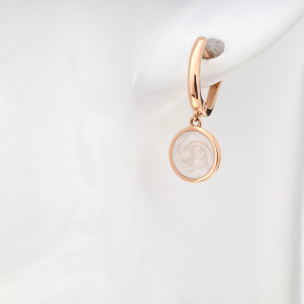 Rose gold hoop earring with cream swirl pendant on white mannequin display.