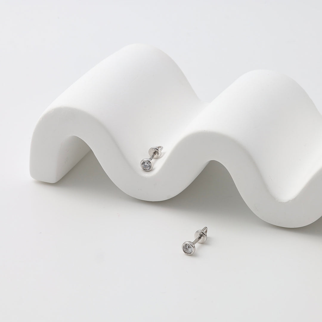 Sterling silver stud earrings with clear round stones on white display, minimalist Ukrainian Jewelry, simple silver studs.