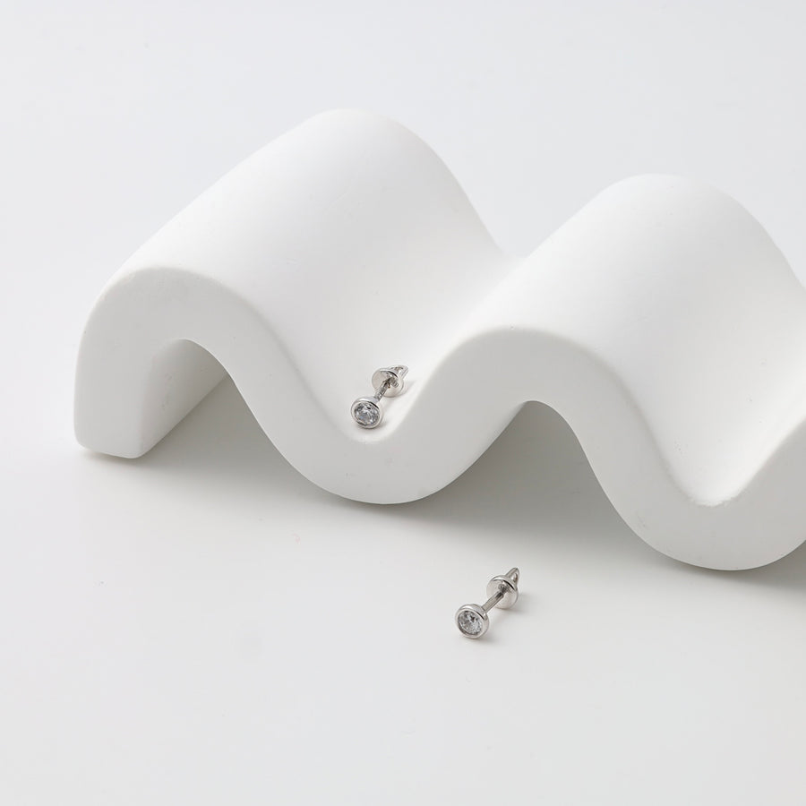 Sterling silver stud earrings with clear round stones on white display, minimalist Ukrainian Jewelry, simple silver studs.