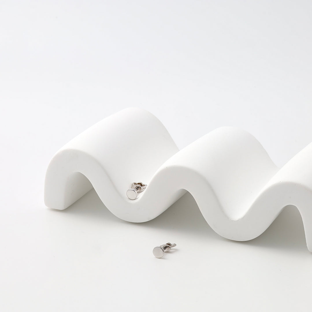 Sterling silver small circle stud earrings displayed on white stand, minimalist Ukrainian Jewelry for everyday silver stud earrings.