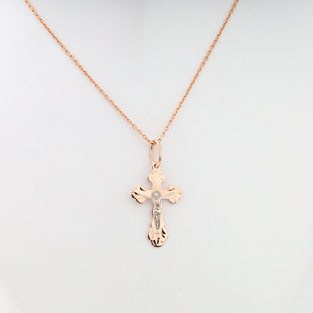 Rose gold cross pendant necklace with silver Jesus figure, displayed on a plain background.