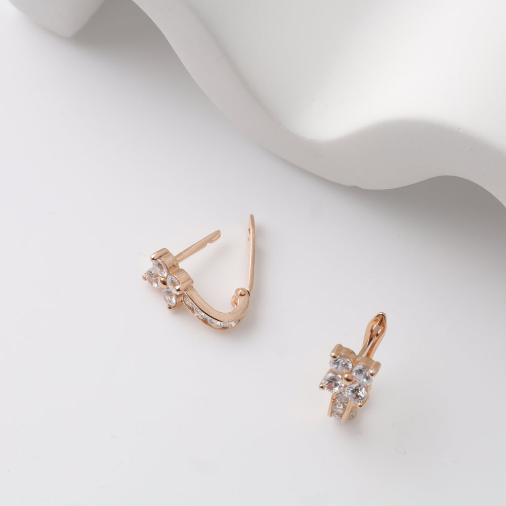 Gold hoop earrings with crystal accents on white background.