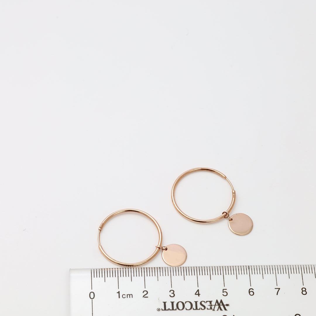 Pair of 14k gold hoop earrings with round disc charms on white background, minimalist Ukrainian Jewelry for everyday gold hoop earrings.