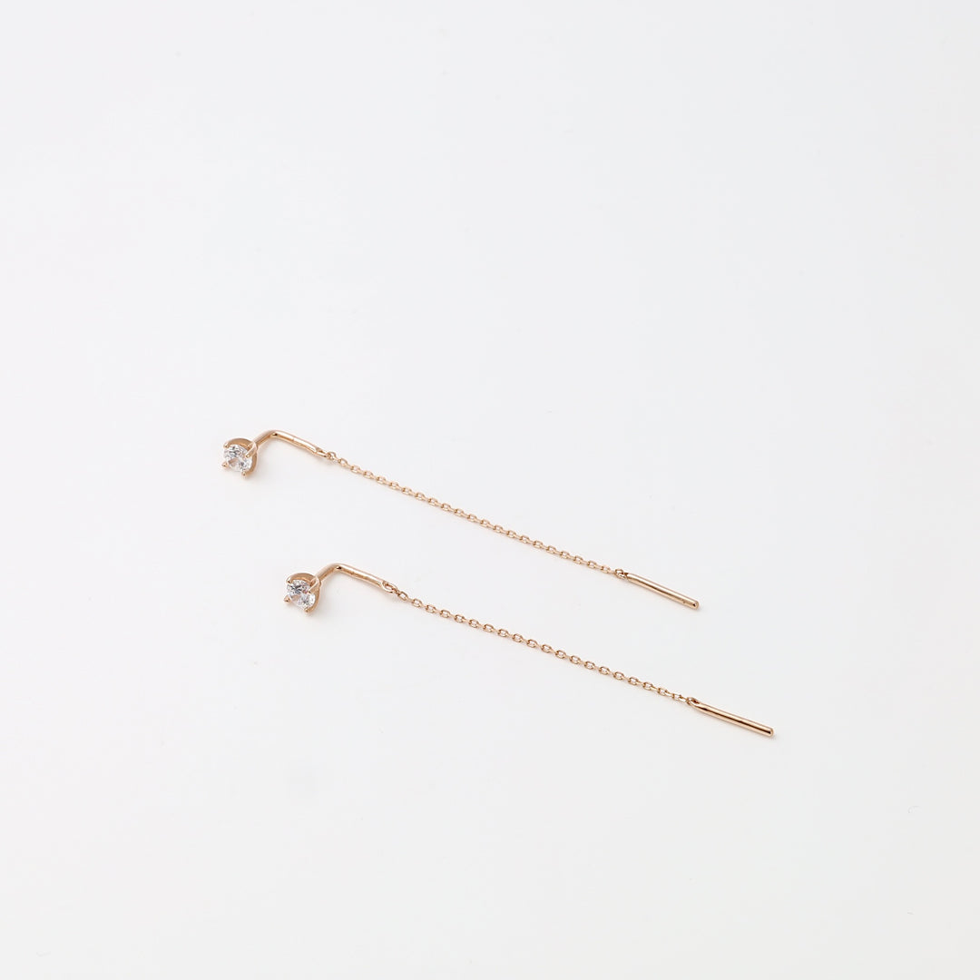 Pair of 14k gold threader earrings with small clear stones on a white background, minimalist Ukrainian Jewelry for women.