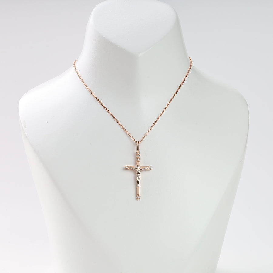 Gold chain necklace with a crucifix pendant featuring Jesus, displayed on a white jewelry bust.