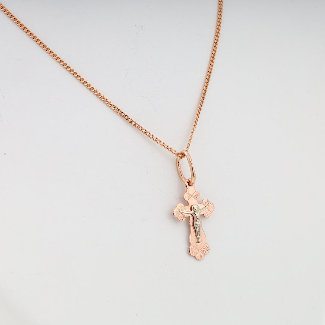 Rose gold cross pendant necklace with silver Jesus motif shown on a simple chain against a white background.
