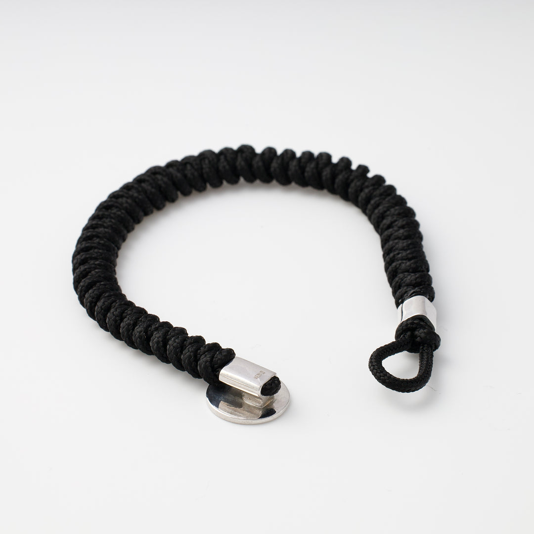 Black cord bracelet with silver clasp, shown on a white background. Rope bracelet, men's jewelry, unisex accessories.