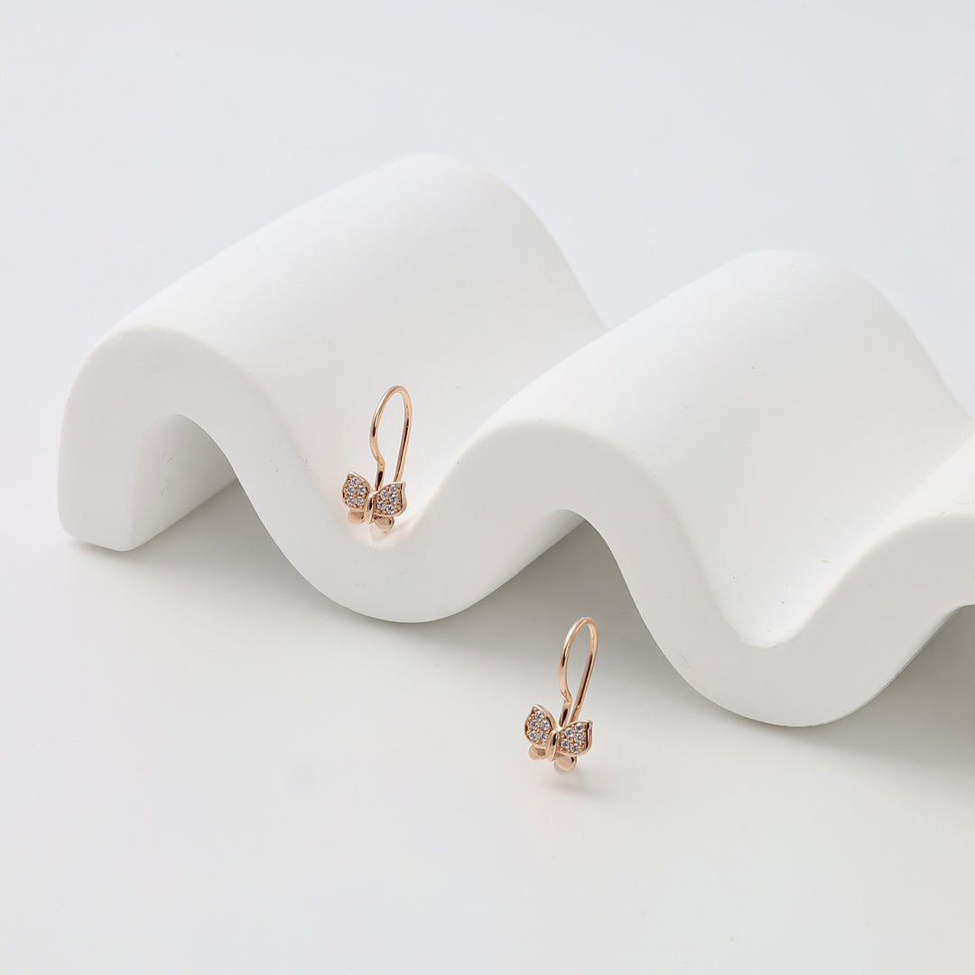 14k gold butterfly drop earrings with small crystals on a white display, Ukrainian Jewelry, delicate gold dangle earrings.